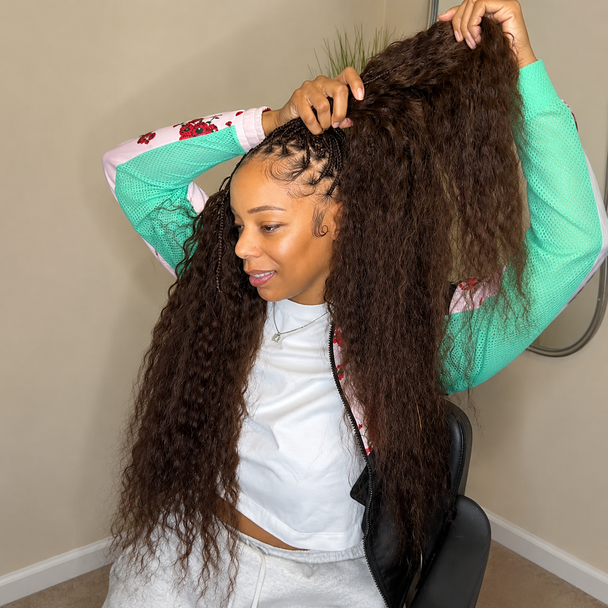 Woman displaying long Dark Brown #2 Wet & Wavy human hair for braiding.