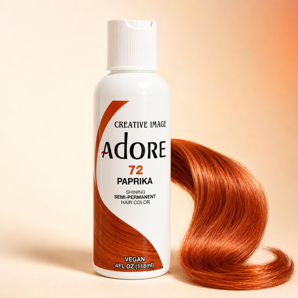 A bottle of Creative Image Adore 72 Paprika semi-permanent hair color stands next to a flowing, glossy copper-orange hair swatch on a warm beige background.