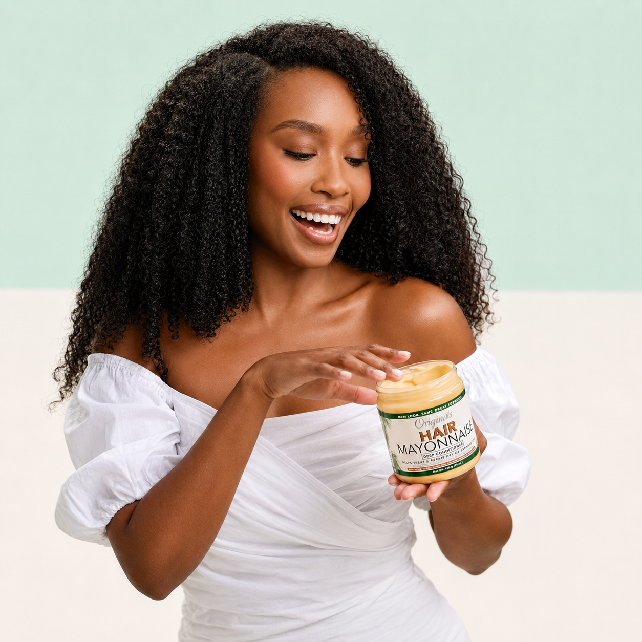 Woman with curly natural hair holding Africa’s Best Originals Hair Mayonnaise Deep Conditioner for damaged hair care