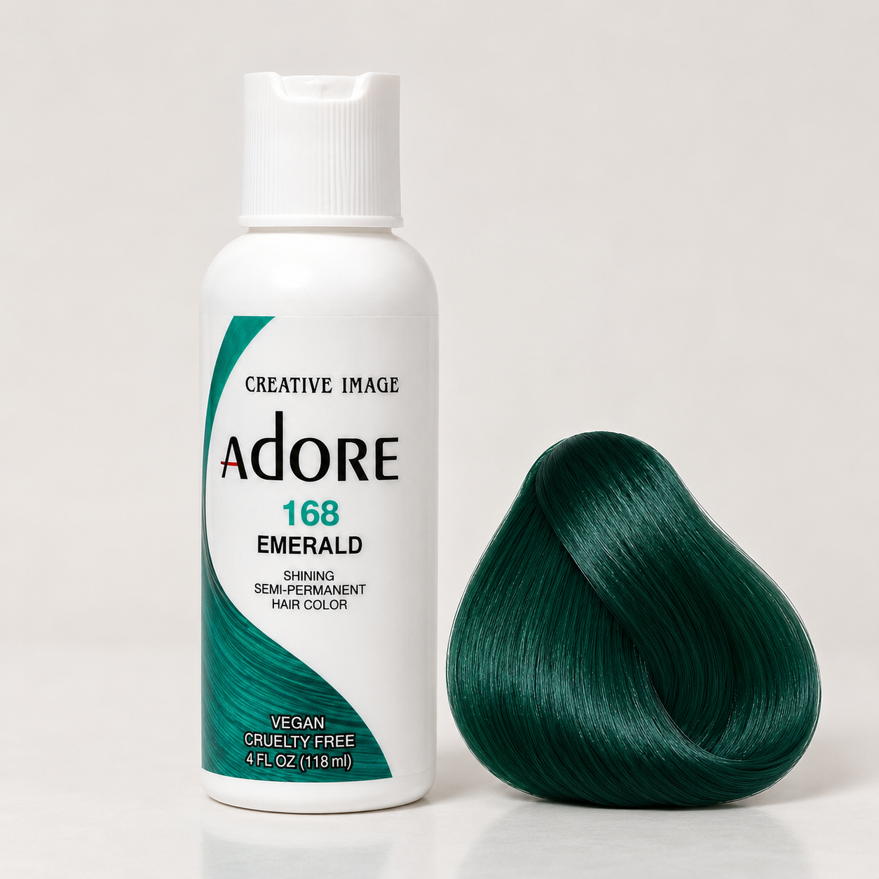 Adore Emerald semi-permanent hair dye beside a glossy deep-green hair-color swatch