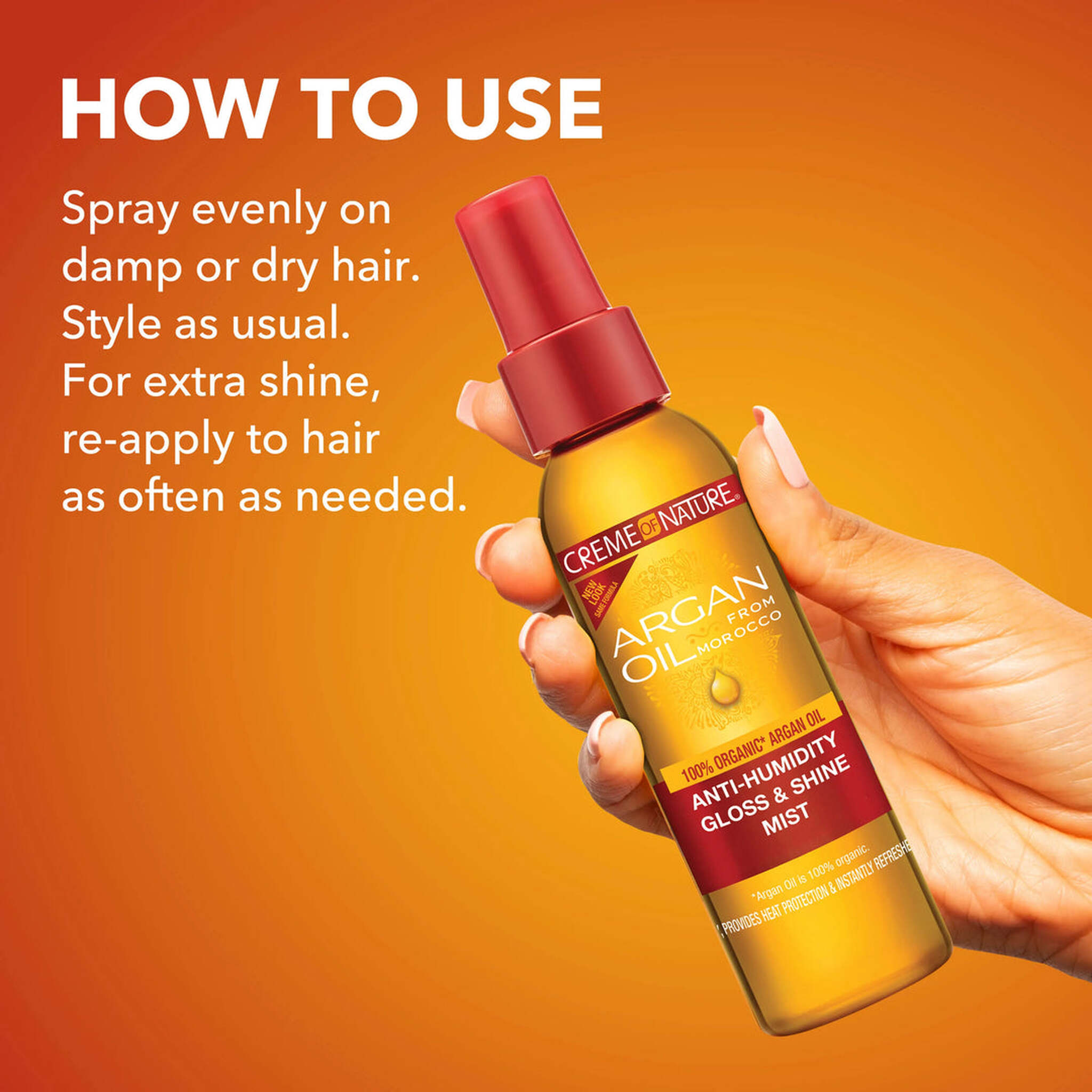 Hand holding a bottle of Crème of Nature Argan Oil spray with usage instructions on an orange background.